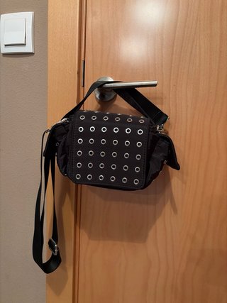 Bolso negro estilo rock chic con tachuelas