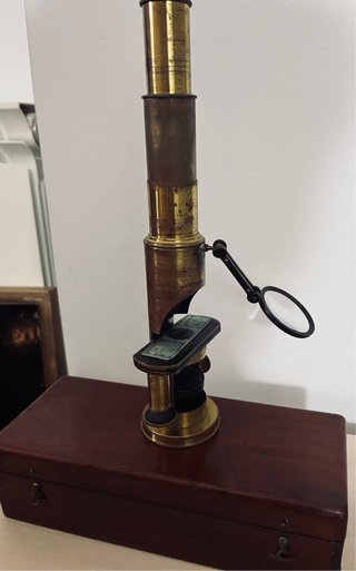 Antiguo microscopio de latón con maletín