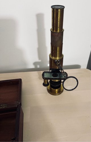 Antiguo microscopio de latón con maletín