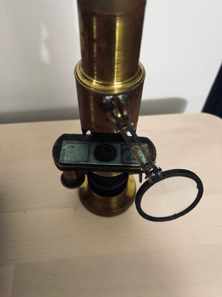 Antiguo microscopio de latón con maletín