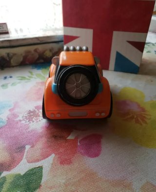 Coche Chicco naranja con número 23