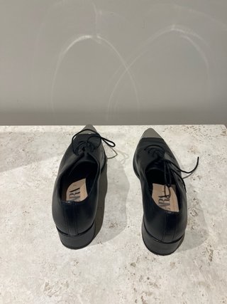 Zapatos negros punta metalizada tacón bajo