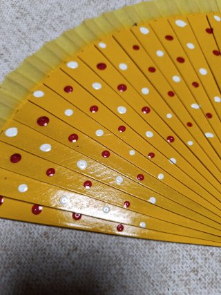 Abanico de madera amarillo con lunares pintados
