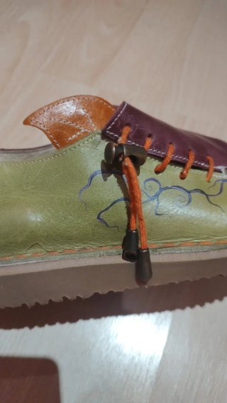 Zapatos artesanos de cuero verde y morado.