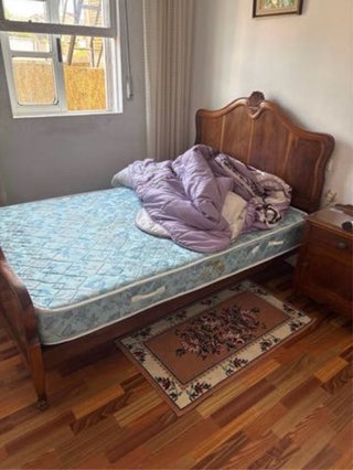 Cama de madera con cabecero tallado