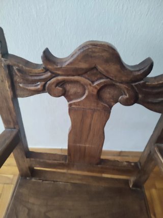 Antigua silla baja de castaño tallada