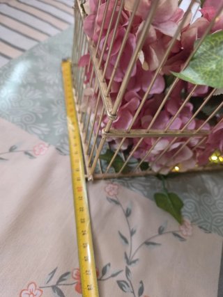 Jaula decorativa dorada con flores y luces