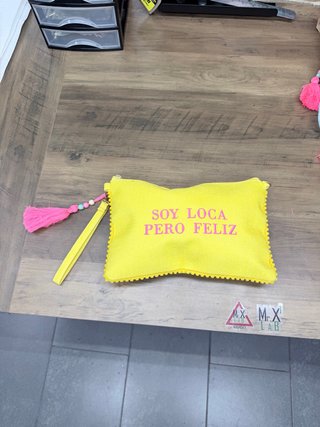 Pochette gialla con scritta Soy Loca Pero Feliz