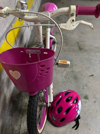 Bicicleta infantil rosa con cesta y casco