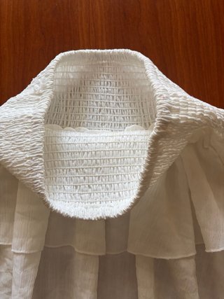 Falda blanca con volantes y cintura ajustable.