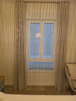 Ventana blanca con persiana.