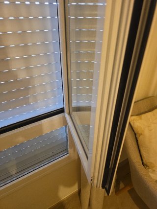 Ventana blanca con persiana.