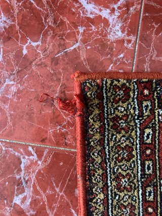 Alfombra de pasillo roja con diseño geométrico