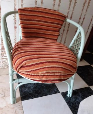 Sillón de bambú con cojines.