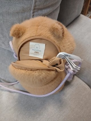 Bolso peluche capibara con flor morada, de Zara.