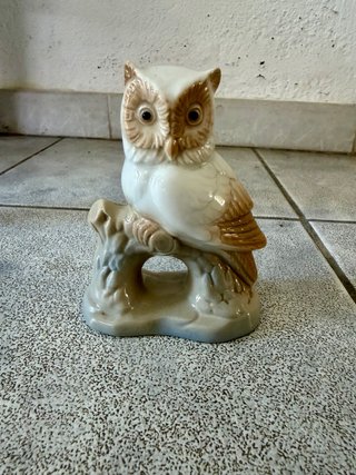 Búho de porcelana sentado en rama