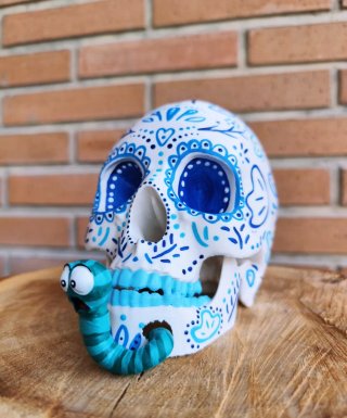 Calavera decorada azul con gusano