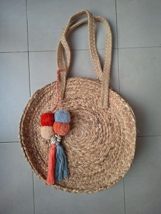 Bolso de rafia redondo con pompones