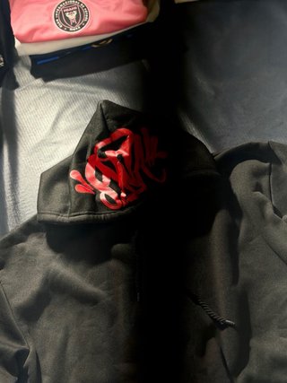 Sudadera Negra Syna con Diseño en Capucha