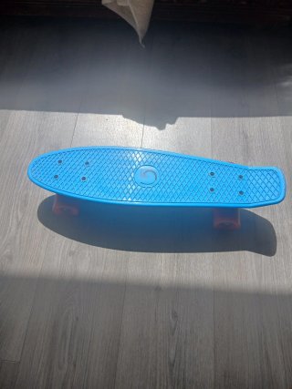 Monopatín azul con ruedas rojas