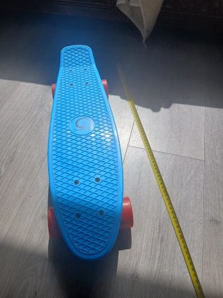 Monopatín azul con ruedas rojas