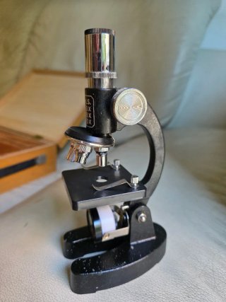 Caja de madera con microscopio y accesorios