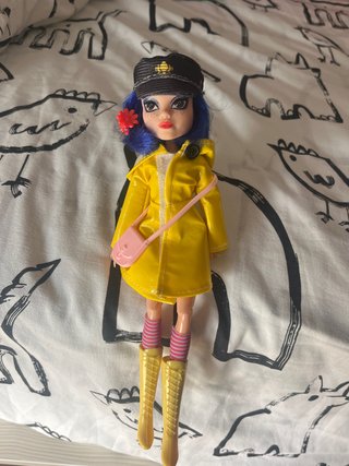 Muñeca Coraline con impermeable amarillo