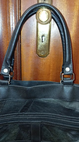 Bolso de piel negro con múltiples bolsillos