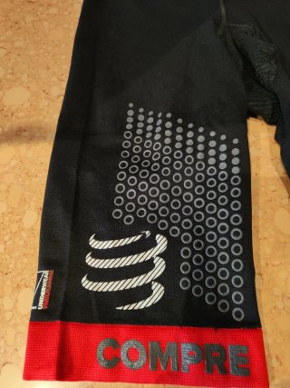 Mallas Compressport atletismo negras y rojas