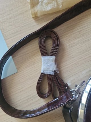 Bolso de cuero marrón con cierre de boquilla