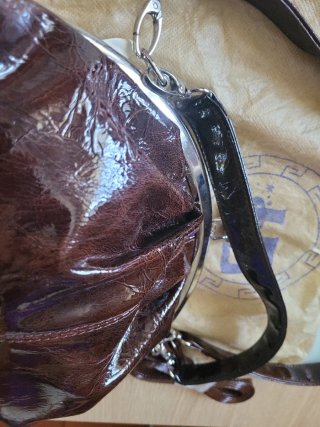 Bolso de cuero marrón con cierre de boquilla