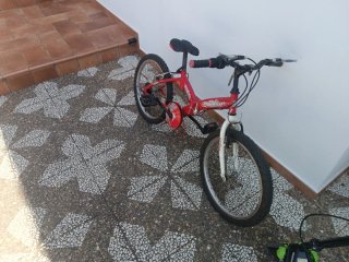 Bicicleta roja que necesita algún retoque.