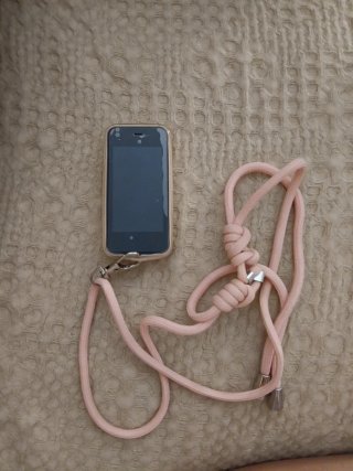 Mini teléfono dorado con cordón rosa