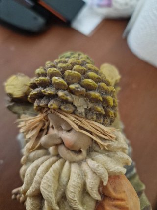 Gnomo che dorme su letto di legno