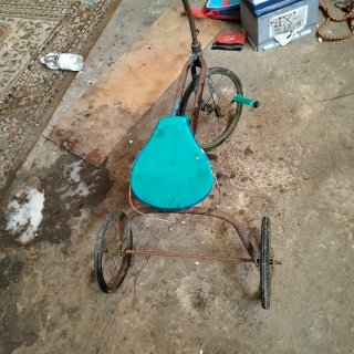 Triciclo antiguo con asiento azul