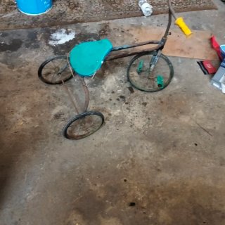 Triciclo antiguo con asiento azul