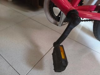 Bicicleta infantil rosa con ruedines y casco