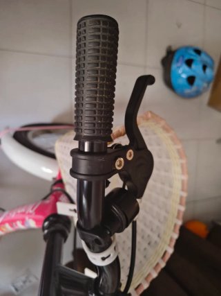 Bicicleta infantil rosa con ruedines y casco