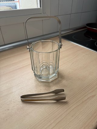 Cubo de hielo de cristal con pinzas