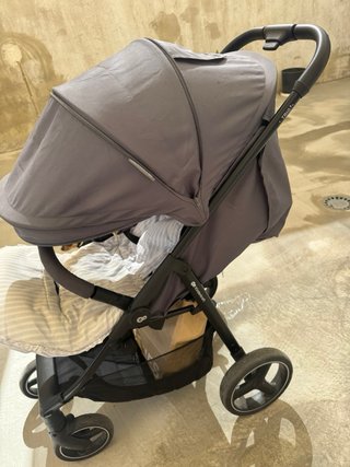 Carrito de bebé gris con funda y plástico