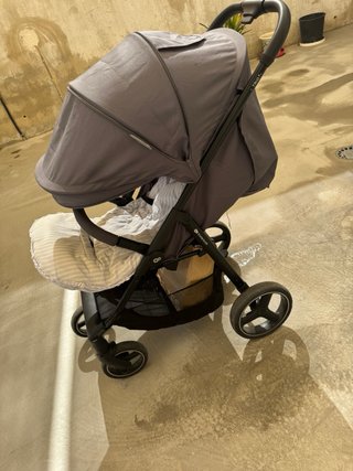 Carrito de bebé gris con funda y plástico