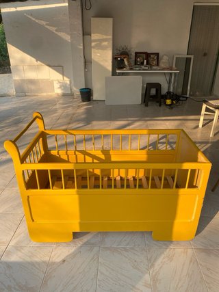 Cuna antigua de madera con ruedas