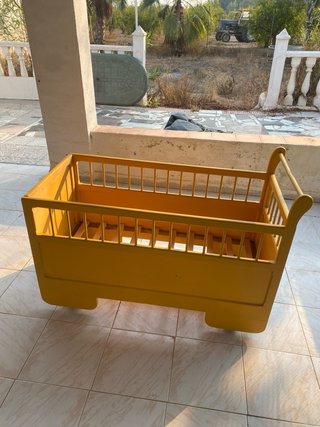 Cuna antigua de madera con ruedas