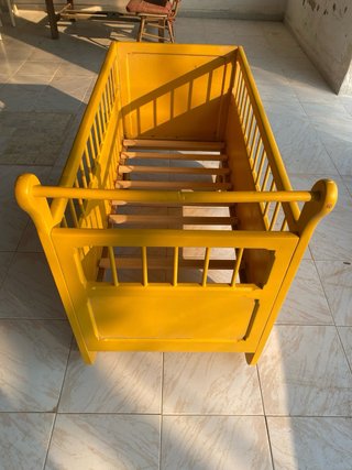 Cuna antigua de madera con ruedas