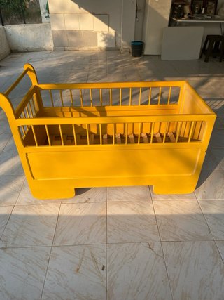 Cuna antigua de madera con ruedas