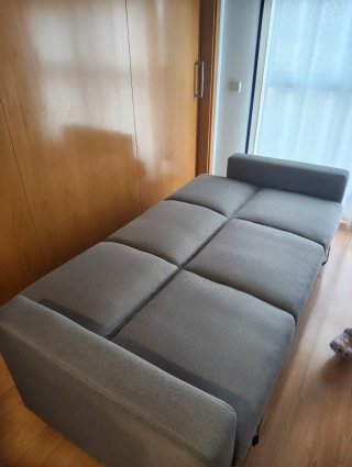 Sofá cama gris con almacenaje y reposapiés