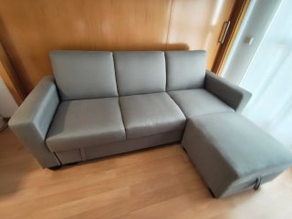 Sofá cama gris con almacenaje y reposapiés