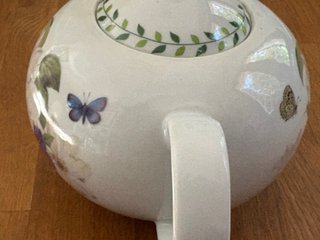 Teiera in porcellana con fiori e farfalle