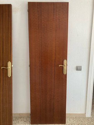 Puerta de madera con manilla dorada