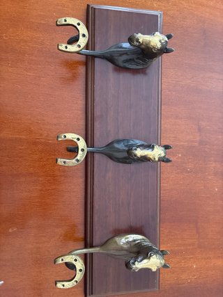 Perchero de madera con caballos y herraduras